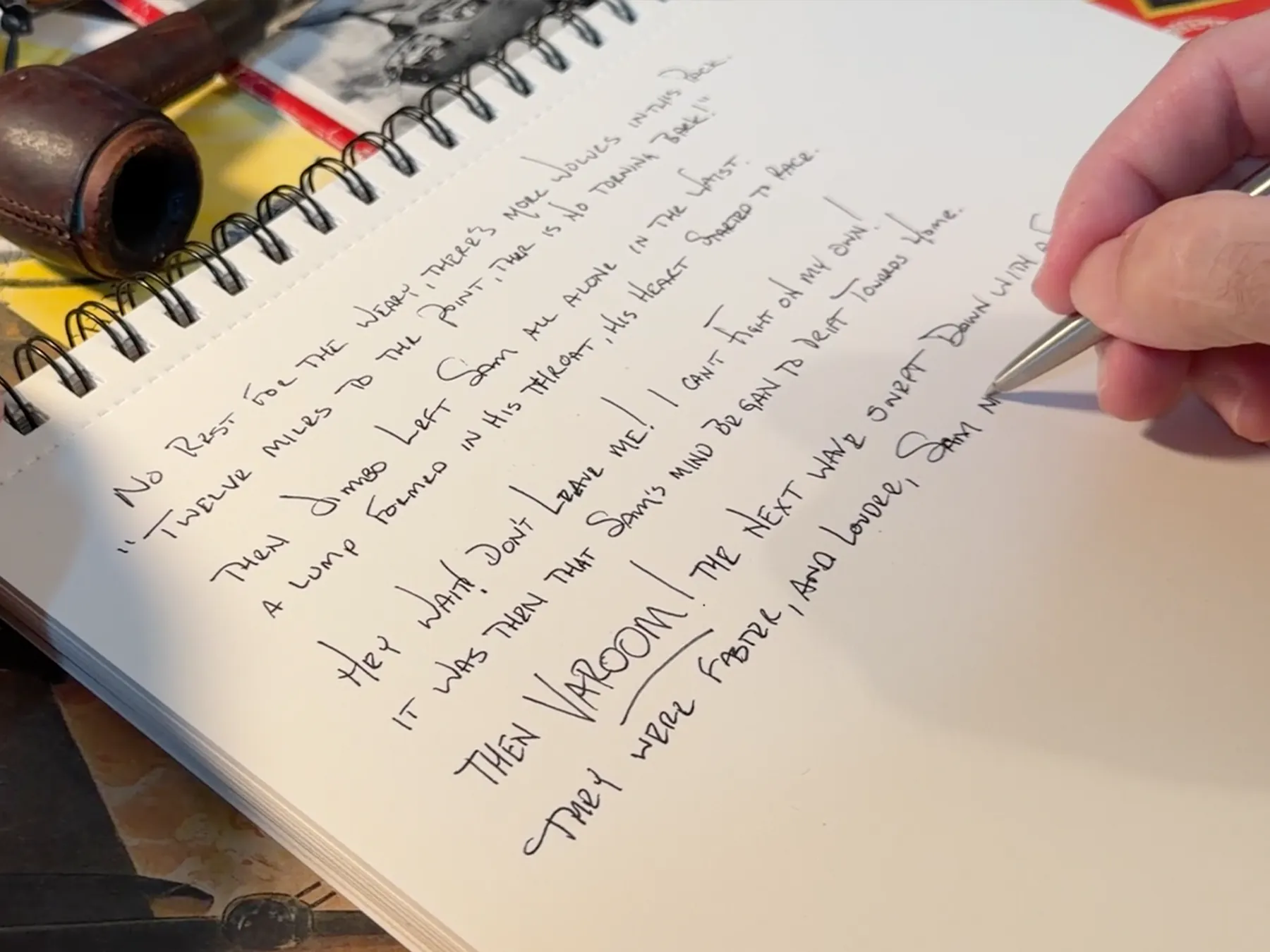 Kenneth Padgett writing The Bomber Boys by hand in a notebook